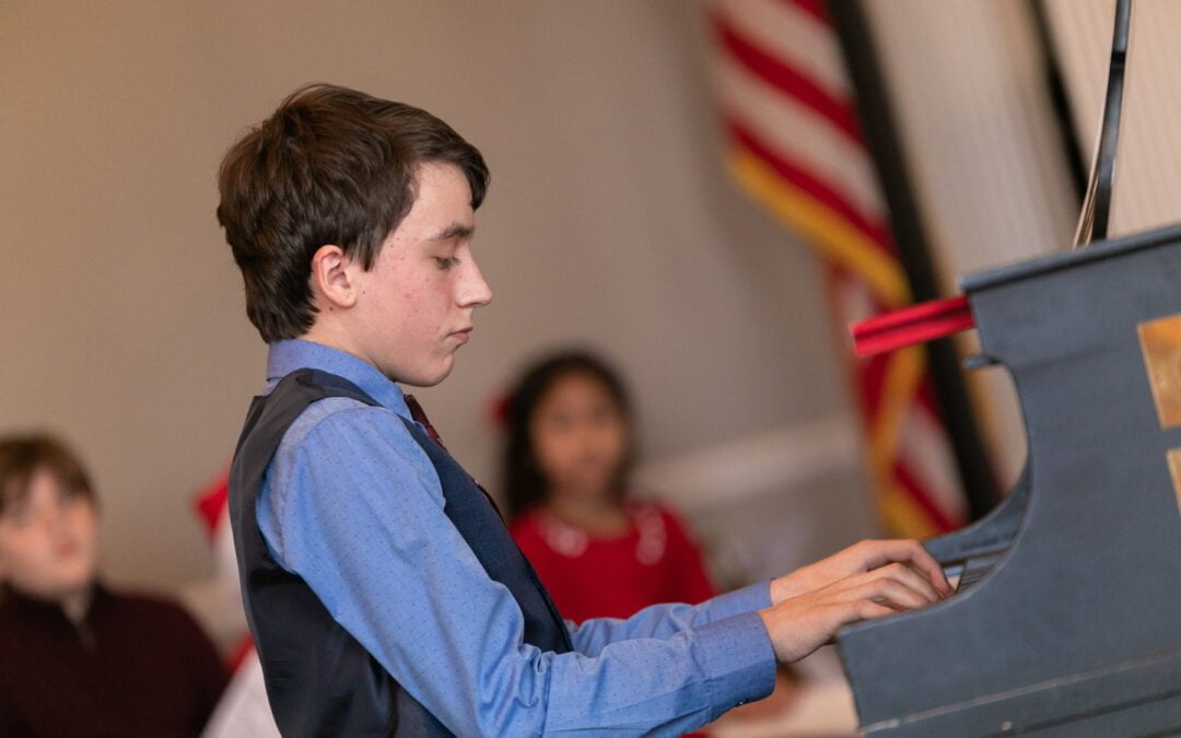 Photo of a student playing the piano at CMS' Holiday Recital