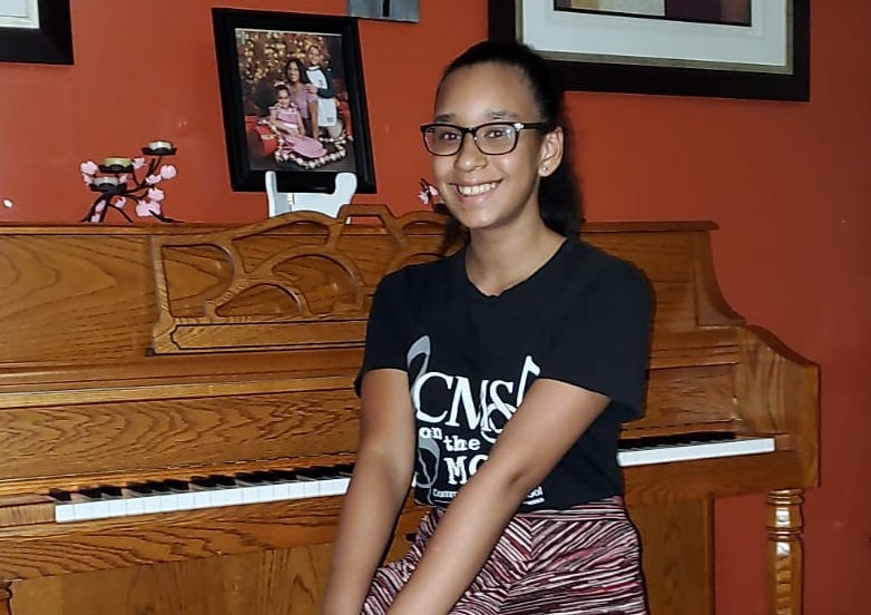Photo of one of our students who received a donated piano.