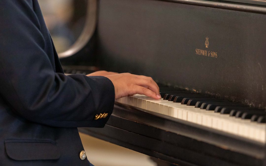 Community music school Steinway grand piano played by a teenage piano student wearing a black suit